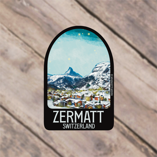 a sticker with a picture of a town in the mountains